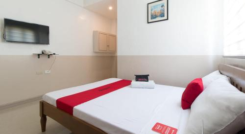1 dormitorio con 1 cama con manta roja y blanca en Softwind Villa Hotel and Resort en Santa Catalina