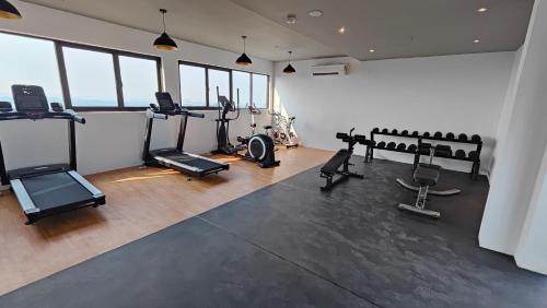 a gym with treadmills and exercise bikes in a room at Afidea Homestay Kids Friendly Condo In Nilai-Netflix,Game in Nilai