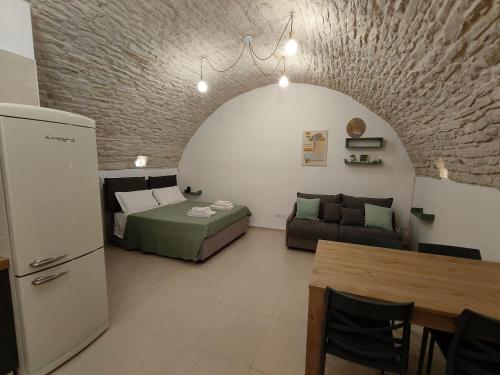 a living room with a bed and a couch at Corte Pietrantica - Charming Rooms & Suites in Giovinazzo