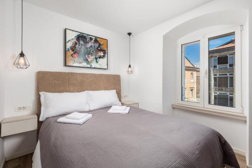 sypialnia z dużym łóżkiem i oknem w obiekcie Apartment Wow w mieście Rijeka