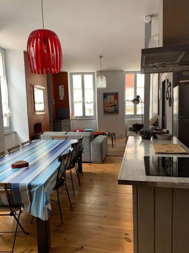 une cuisine et un salon avec une grande table dans une pièce dans l'établissement Grand appartement 2 à 8 personnes, à Cauterets
