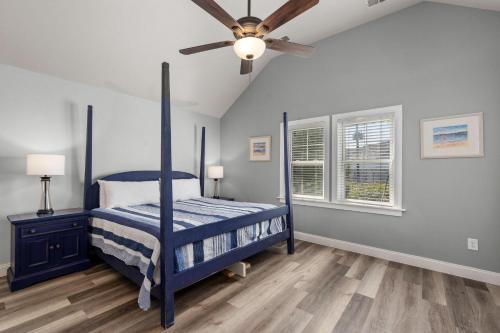 a bedroom with a blue bed and a ceiling fan at SH450 Sea You Soon in Southern Shores