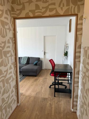 a living room with a table and a couch at Appartement rénové et spacieux, Terrasse, 4 pers in Franconville