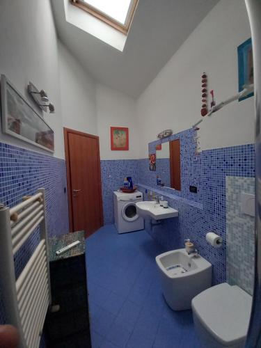 uma casa de banho azul e branca com um WC e um lavatório em "La Casita", 2 Floors Apartment, Private Parking 1 car OR 2 Bikes, Air-Cond and Terrace em Livorno