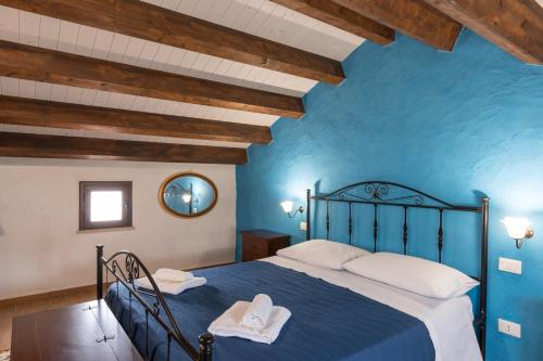 a blue bedroom with a bed and a mirror at Villa Siciliana con piscina privata in Buseto Palizzolo