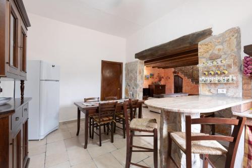 a kitchen with a wooden table and some chairs at Villa Siciliana con piscina privata in Buseto Palizzolo