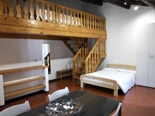 uma sala de estar com uma cama alta e uma mesa em Appartamenti Frescobaldi em Ferrara