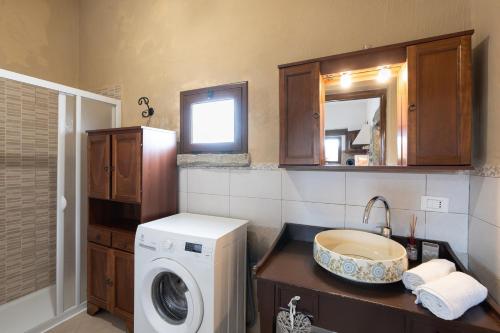 a bathroom with a washing machine and a sink at Villa Siciliana con piscina privata in Buseto Palizzolo
