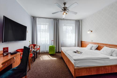 a hotel room with a bed and a flat screen tv at Hotel Bristol in Kielce