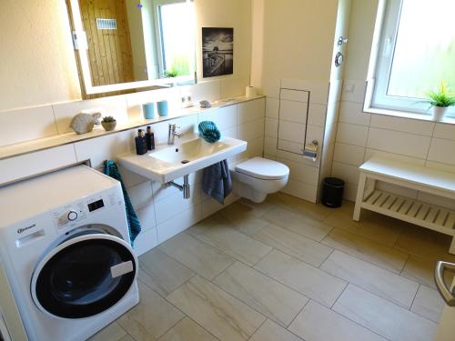 a bathroom with a washing machine and a sink at Gode Wind Quartiere 4 in Dahme