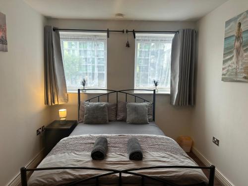a bed in a bedroom with two windows at ABBA Heights in London
