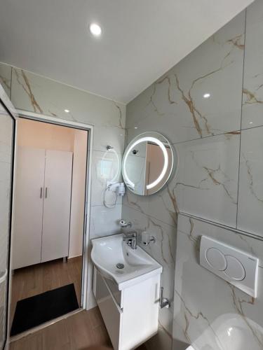 W łazience znajduje się umywalka i lustro. w obiekcie Vila Melina w mieście Ksamil
