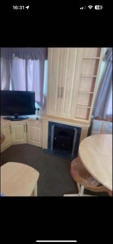 een kamer met een tafel en een televisie en een tafel en stoelen bij Julie's caravans in Lincolnshire