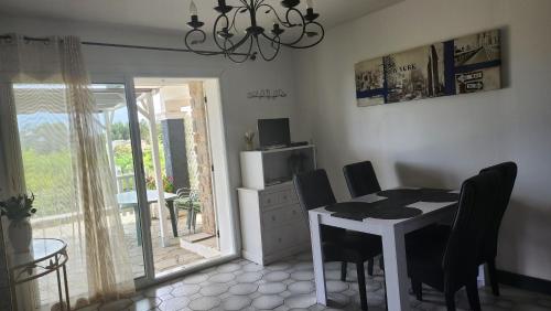 une salle à manger avec une table et des chaises et un balcon dans l'établissement T3 .Vue.jardin Terrasse Parking., à Carqueiranne
