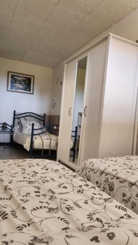 une chambre avec deux lits et un miroir dans l'établissement T3 .Vue.jardin Terrasse Parking., à Carqueiranne