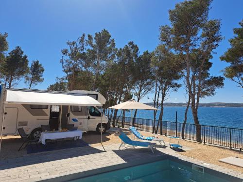a rv parked next to a swimming pool next to the water at Aminess Style Camping Avalona Resort - Pitches in Povljana