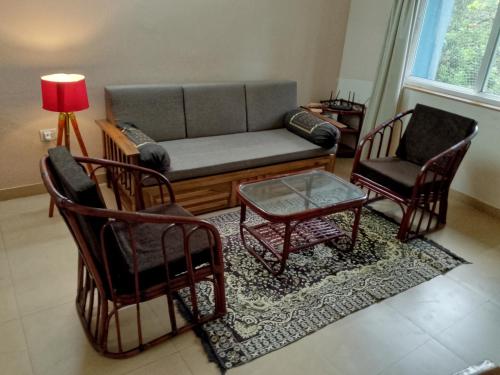una sala de estar con un sofá y dos sillas en Tranquil home near vagator beach, en Anjuna