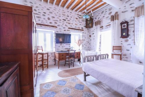 a bedroom with a bed and a desk and a table at Rustic house in Ano Syros in Ano Syros