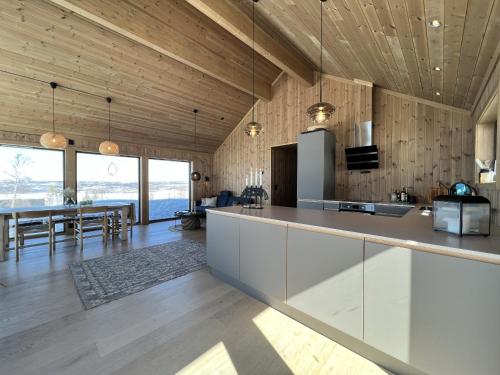 une cuisine avec des placards blancs et une salle à manger dans l'établissement Golsfjellet - new modern cabin with fantastic view, à Golsfjellet