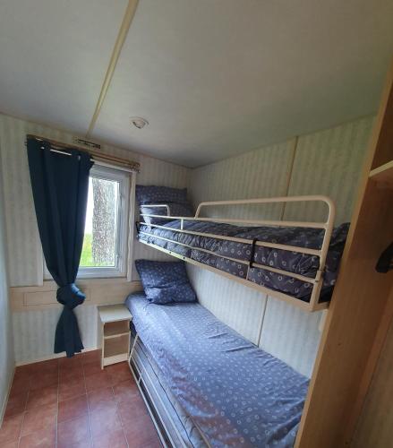 une chambre avec deux lits superposés et une fenêtre dans l'établissement Camping du Lac, à Égletons