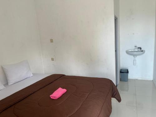 a bed with a pink towel on it in a room at Gangga Guest House Bromo in Ngadisari