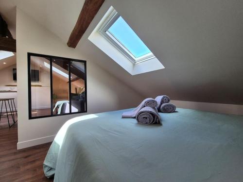 - une chambre avec un lit, des serviettes et une fenêtre dans l'établissement Le Saint-Aubin, à Angers