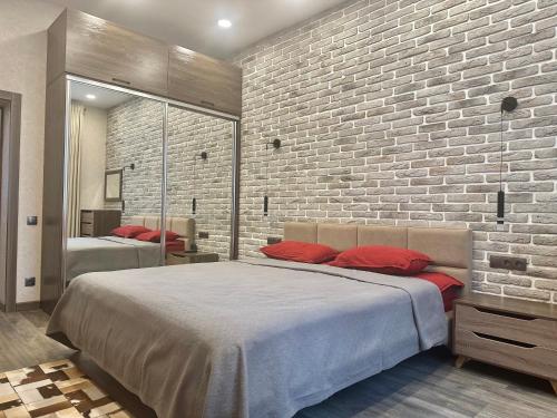 - une chambre avec 2 lits et un mur en briques dans l'établissement Apartment in Tashkent City Center, à Yakkasaray