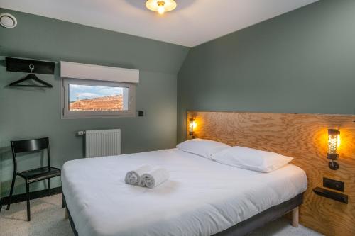 a bedroom with a bed with two towels on it at Eklo Bordeaux Centre Bastide in Bordeaux