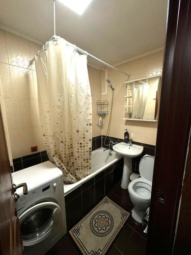 y baño con aseo, lavabo y ducha. en Квартиры рядом с Аэропортом города Алматы, en Turksib