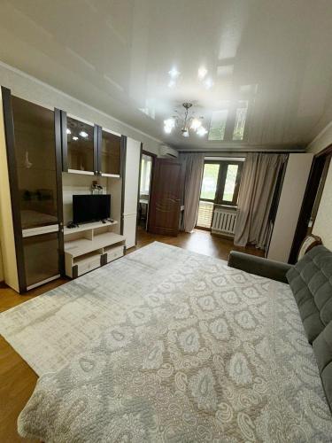 sala de estar con sofá y alfombra grande en Квартиры рядом с Аэропортом города Алматы en Turksib