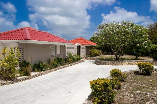 a house with a red roof and a driveway at Villa Mongoose - vue exceptionnelle in Les Terres Basses