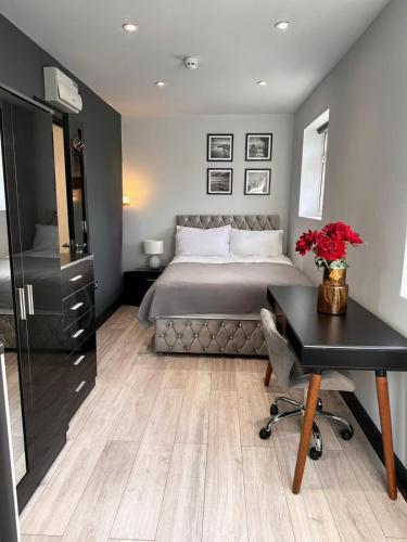 a bedroom with a bed and a desk and a desk at Private Family and Business Rooms Harrow Fast WiFi in Pinner