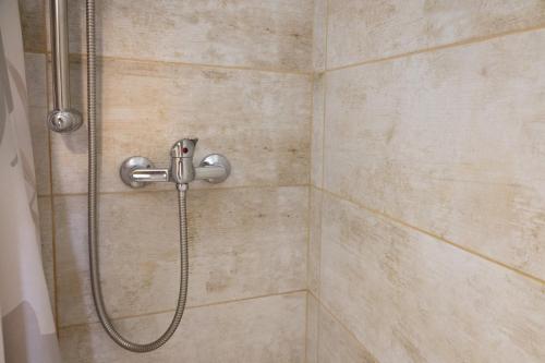 a shower with a shower head in a bathroom at Sant' Elena Room in Bale