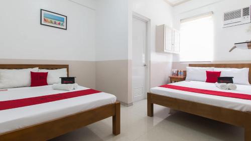 1 dormitorio con 2 camas y ventana en Softwind Villa Hotel and Resort en Santa Catalina