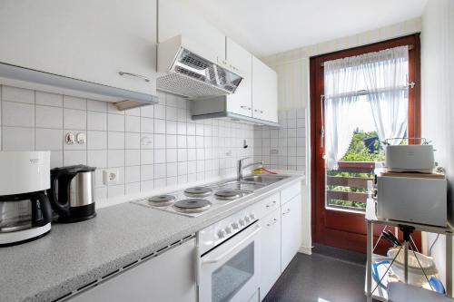 a kitchen with white appliances and a window at Hoern 2 in Nordstrand