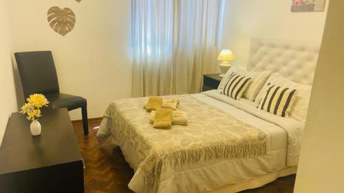Un dormitorio con una cama con toallas amarillas. en Calido en Mendoza