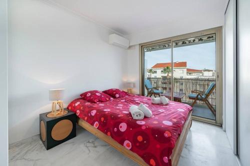 une chambre avec un lit et une grande fenêtre dans l'établissement Cannes superbe appartement renové, à Cannes