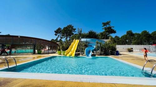 a pool with a slide and a water park at Mobilhome climatisé, 6 personnes camping les embruns in Lège-Cap-Ferret