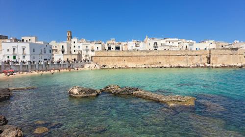 een waterlichaam met een groep gebouwen bij LA CASA DI BEL in Monopoli
