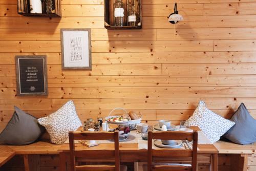 a dining room with a wooden wall and a table with pillows at Ferienanlage Villa Maare in Gillenfeld