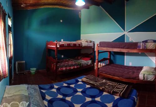a room with two bunk beds and a blue wall at Tilcara Hostel in Tilcara