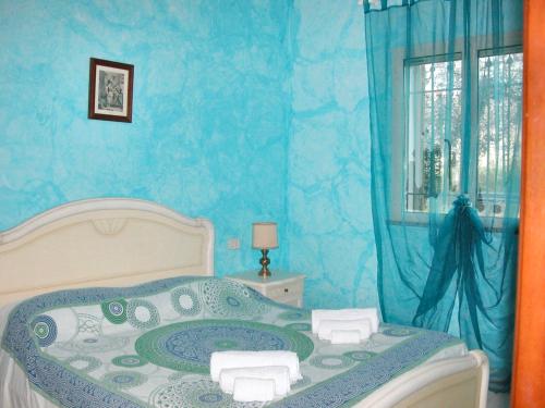 una camera blu con un letto e una finestra di 3 bedrooms house with sea view and enclosed garden at Menfi 1 km away from the beach a Menfi