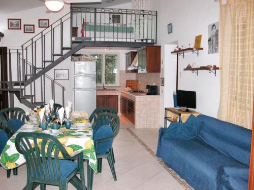 un soggiorno con tavolo e divano blu di 3 bedrooms house with sea view and enclosed garden at Menfi 1 km away from the beach a Menfi