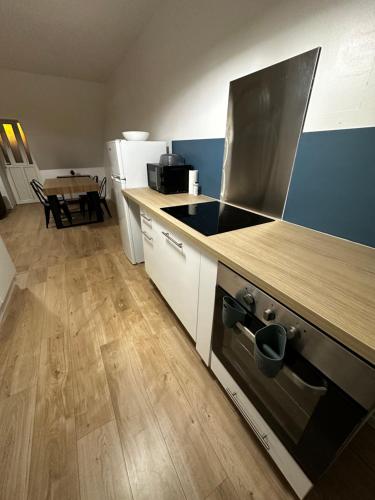 a kitchen with a stove and a wooden counter top at La nouvelle école in Ruillé-en-Champagne