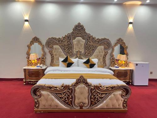 a bedroom with an ornate bed with two night stands at Niagara Falls Bahawalpur in Bahawalpur