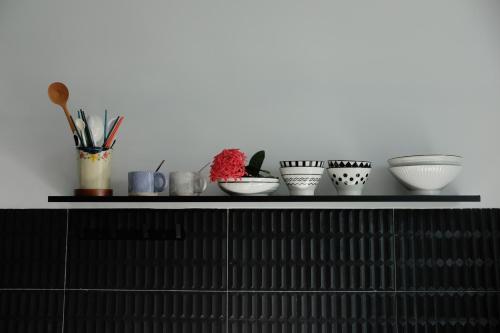 a shelf with bowls and other ceramics on it at Gạo Homestay in Mui Ne