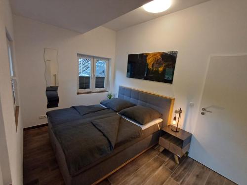 a bedroom with a large bed and two windows at Ferienapartment Zur Bunten Kuh Walporzheim in Bad Neuenahr-Ahrweiler