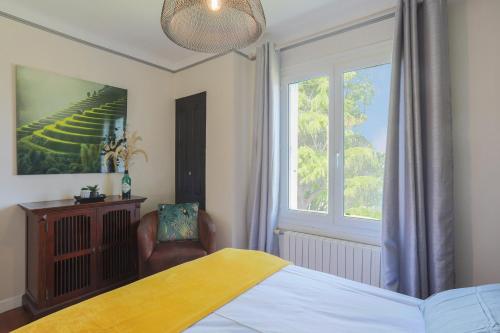 une chambre avec un lit, une fenêtre et une chaise dans l'établissement Maison proche mer Plouha, à Plouha