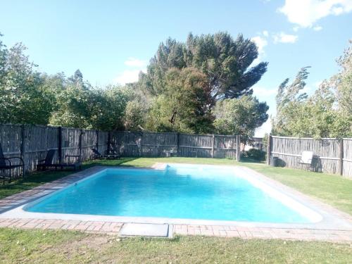 a swimming pool in a yard with a fence at Wagon Wheel Country Lodge in Beaufort West