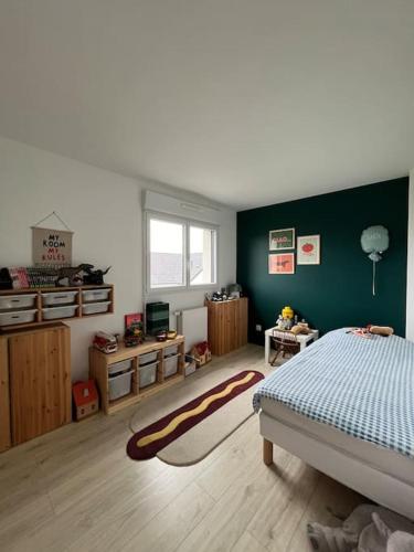 a bedroom with a bed and a green wall at La Casa Familia à Fontainebleau in Grez-sur-Loing